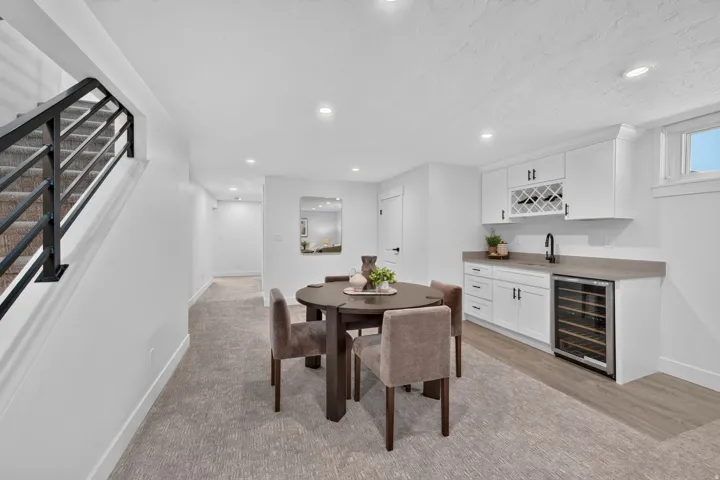 Wet bar with white cabinetry, built-in wine rack, and beverage refrigerator
