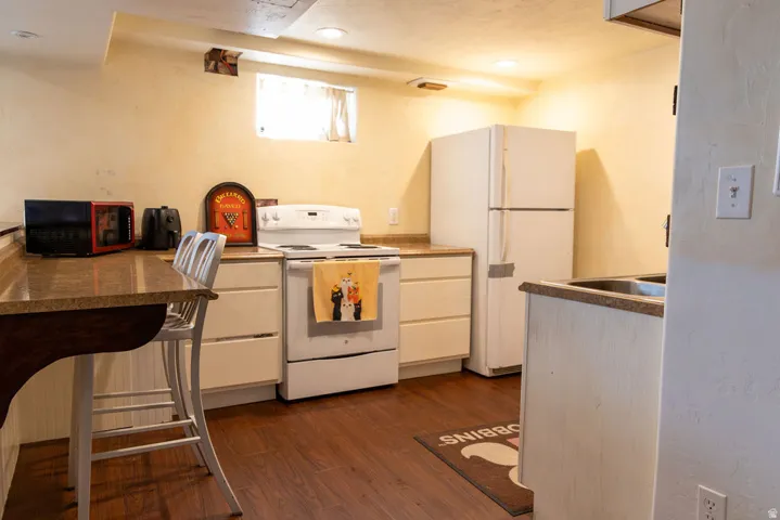 Hard-surface flooring, white appliances, light-toned cabinetry, and light-toned countertops