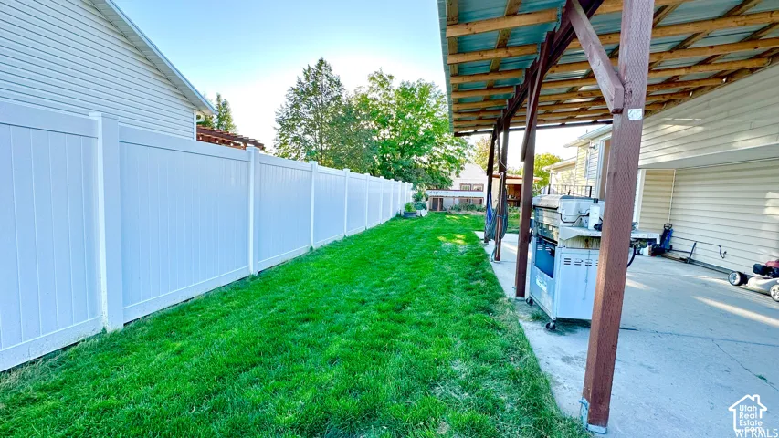 Expansive green lawn alongside a newly installed white vinyl privacy fence