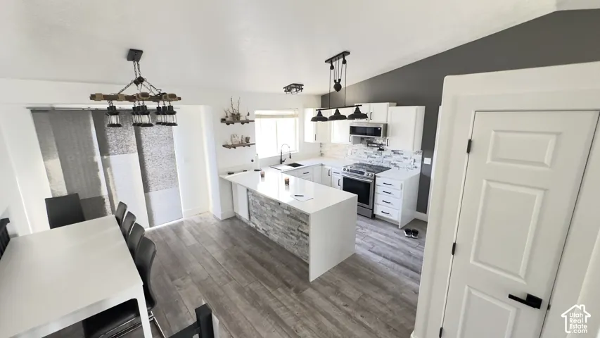Another polished option:**Bright, open-concept kitchen showcasing quartz countertops, a textured stone backsplash, tile flooring, crisp white cabinetry, and premium stainless-steel appliances. The expansive peninsula adds both functionality and style, c