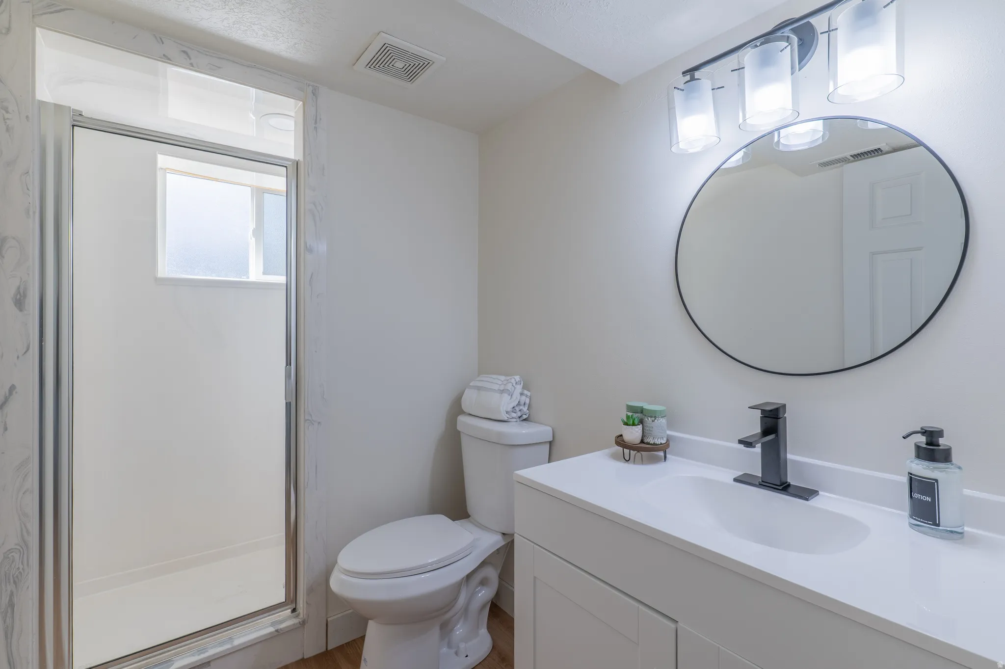 Walk-in shower with clear glass enclosure and window