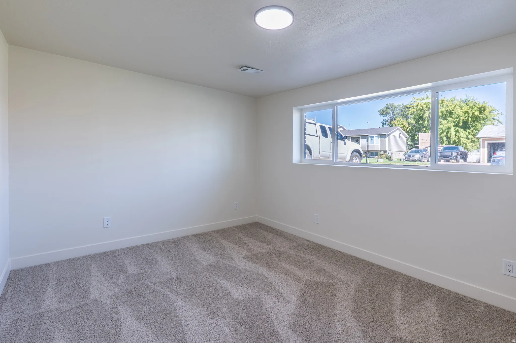 Neutral wall finishes with a large horizontal window and recessed ceiling light