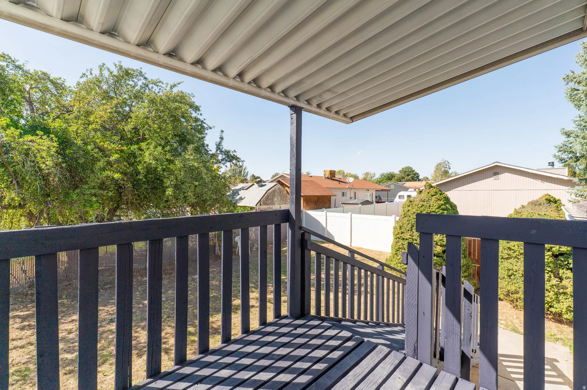 Covered outdoor deck with painted railings and stairs
