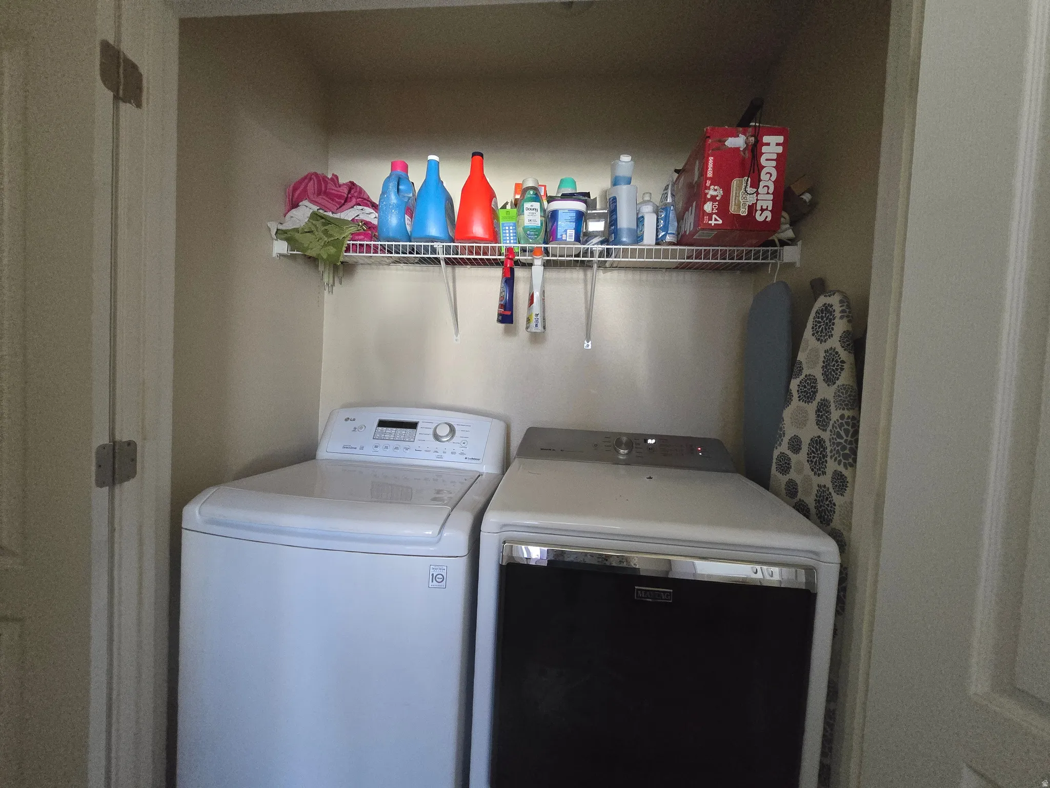 Recessed laundry area featuring a wire storage shelf