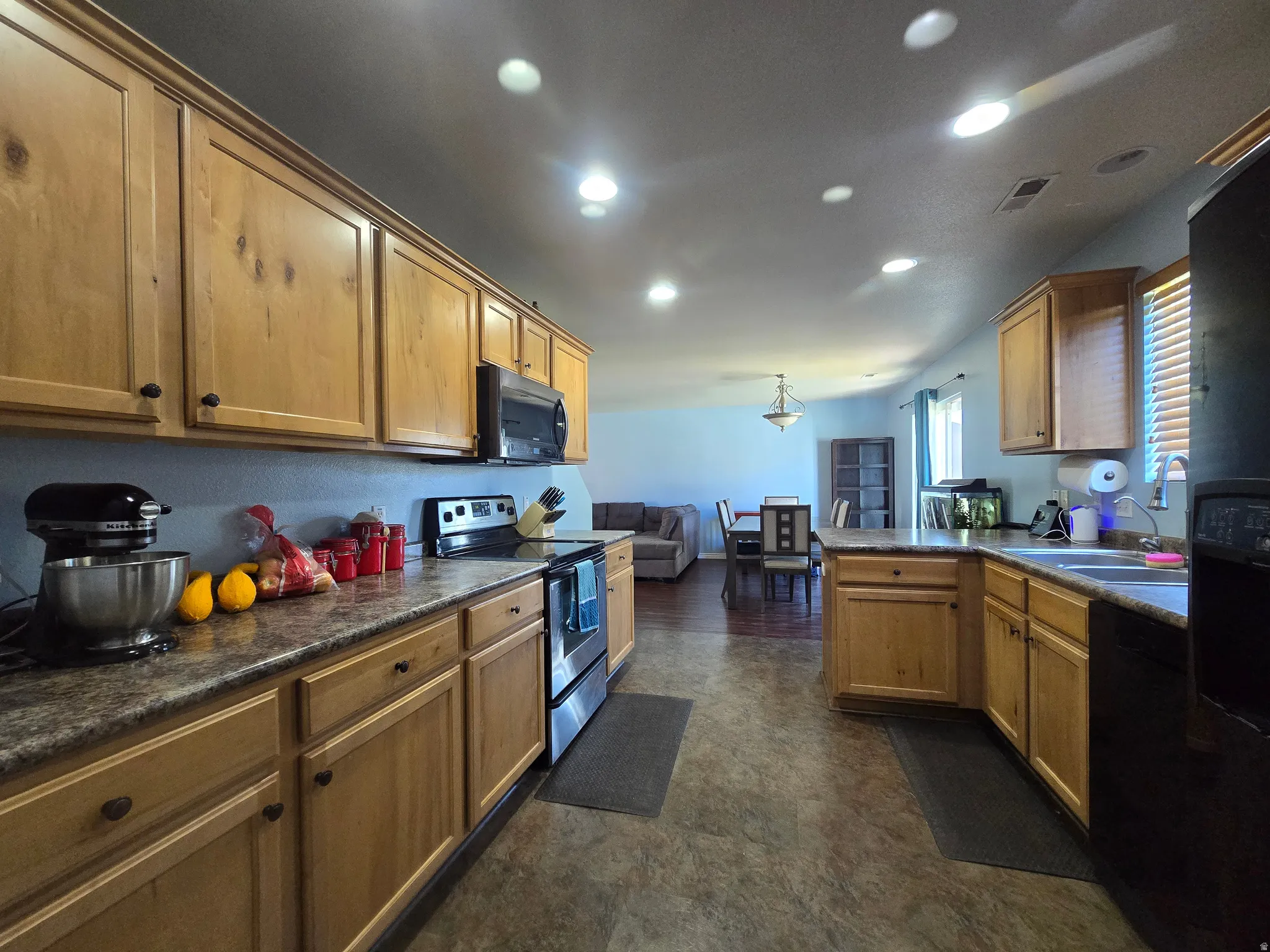 Kitchen with wood-finish cabinetry, stainless steel range, and built-in microwave