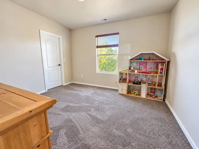 Wall-to-wall carpeting with a neutral tone, light-colored walls, and a window with blinds
