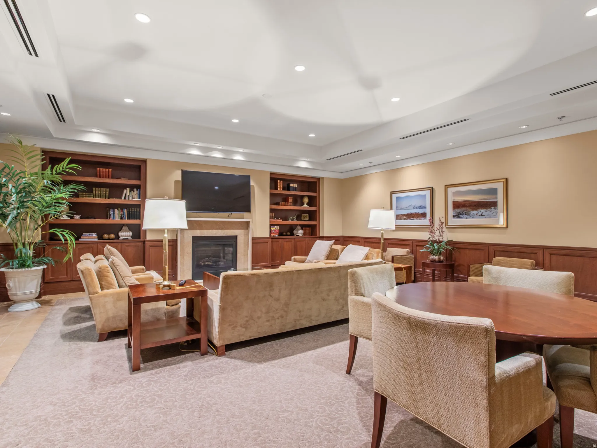 Built-in shelving, wainscoting, recessed lighting, fireplace, and carpet flooring