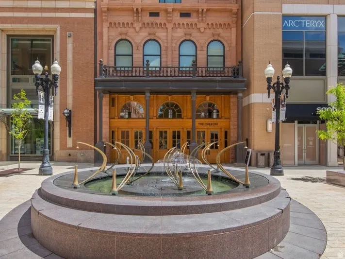 Architectural facade featuring arched windows, decorative brickwork, and a wrought iron balcony