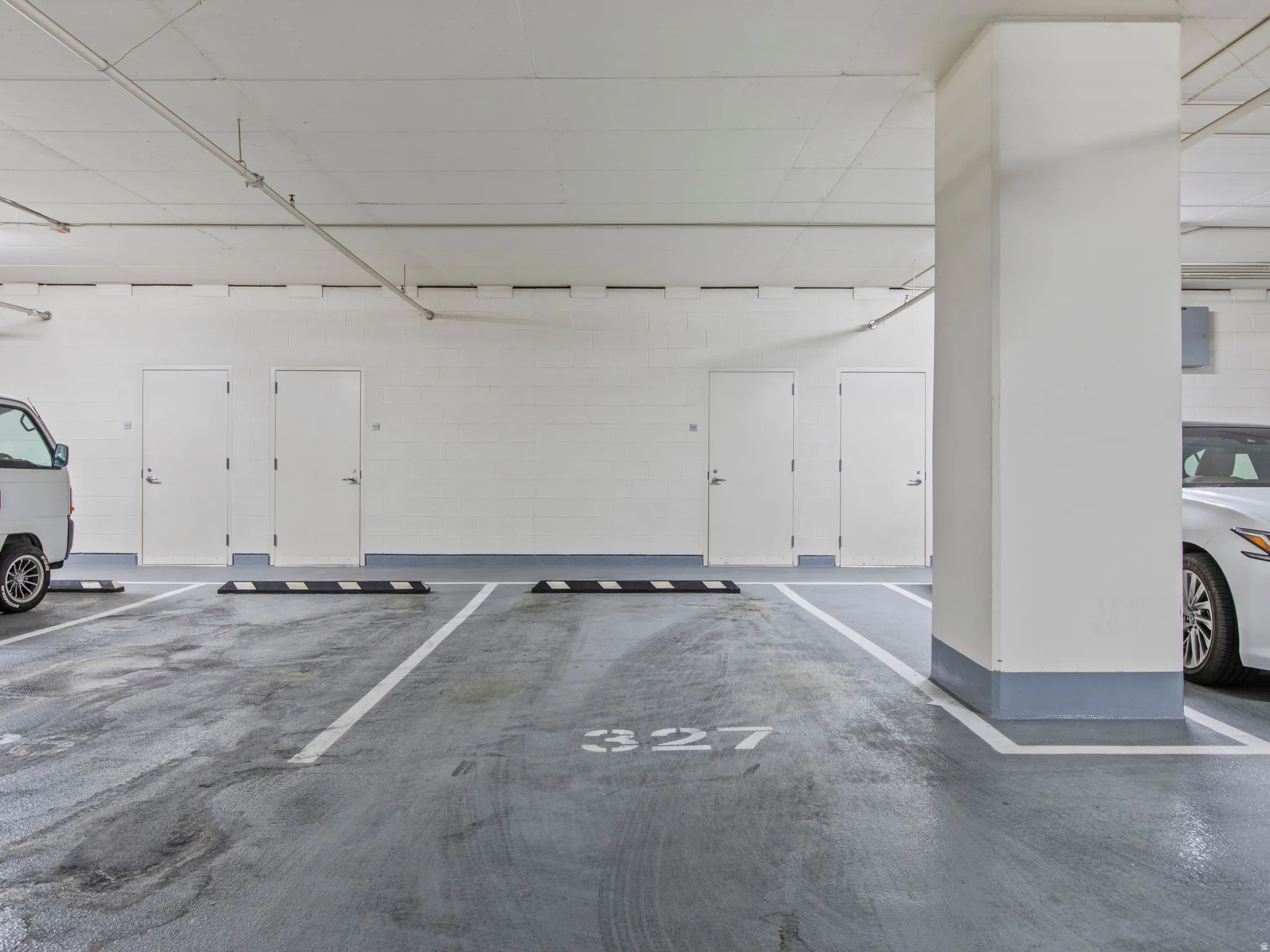 Underground secured parking space with storage ,painted concrete flooring and white wall construction