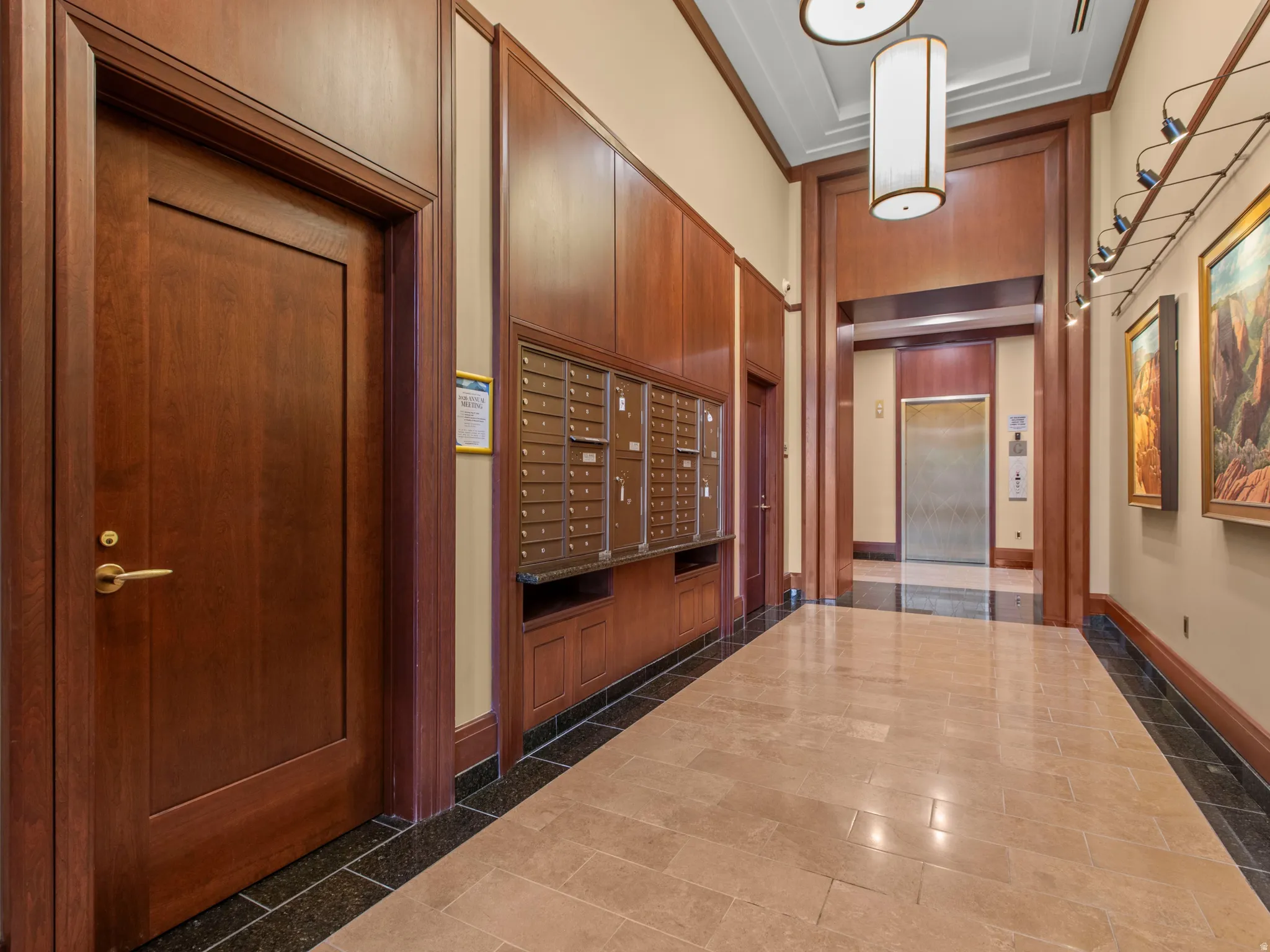 Entryway featuring a tiled floor, wood-paneled walls, built-in mailboxes, and an elevator