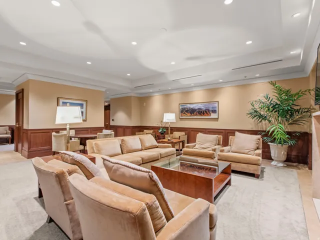 Recessed ceiling lighting, crown molding, wainscoting, and a built-in fireplace feature in this lounge area