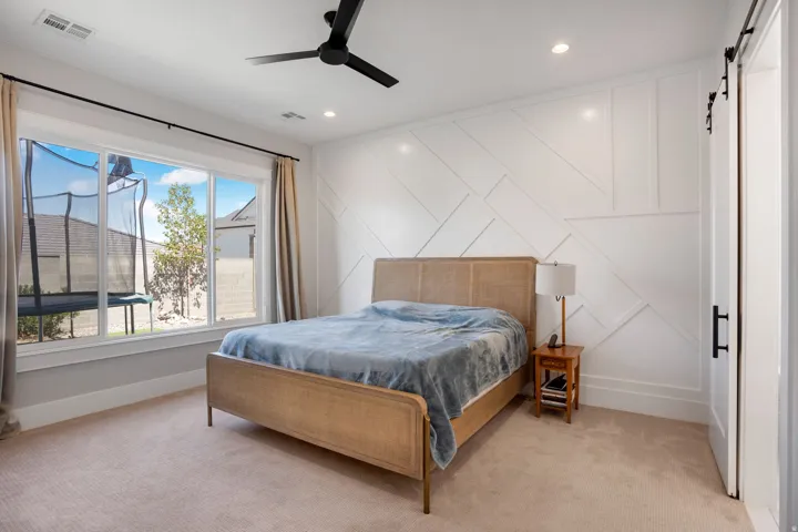 Wall-mounted ceiling fan, recessed lighting, and a feature wall with geometric paneling