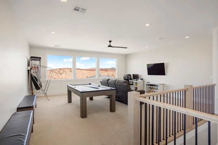 Carpeted open-concept bonus room featuring a three-panel window, recessed lighting, and a ceiling fan
