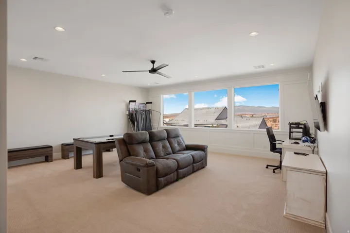 Spacious room featuring carpeting, recessed lighting, and a ceiling fan