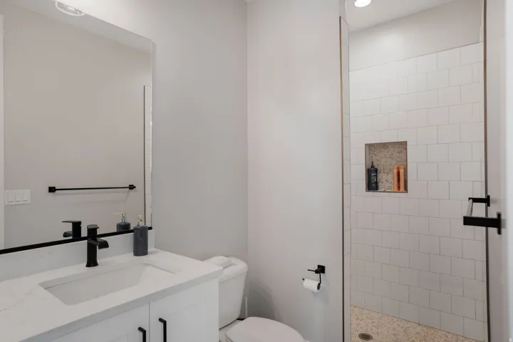 Vanity with a rectangular undermount sink, black-finish faucet, and quartz countertop