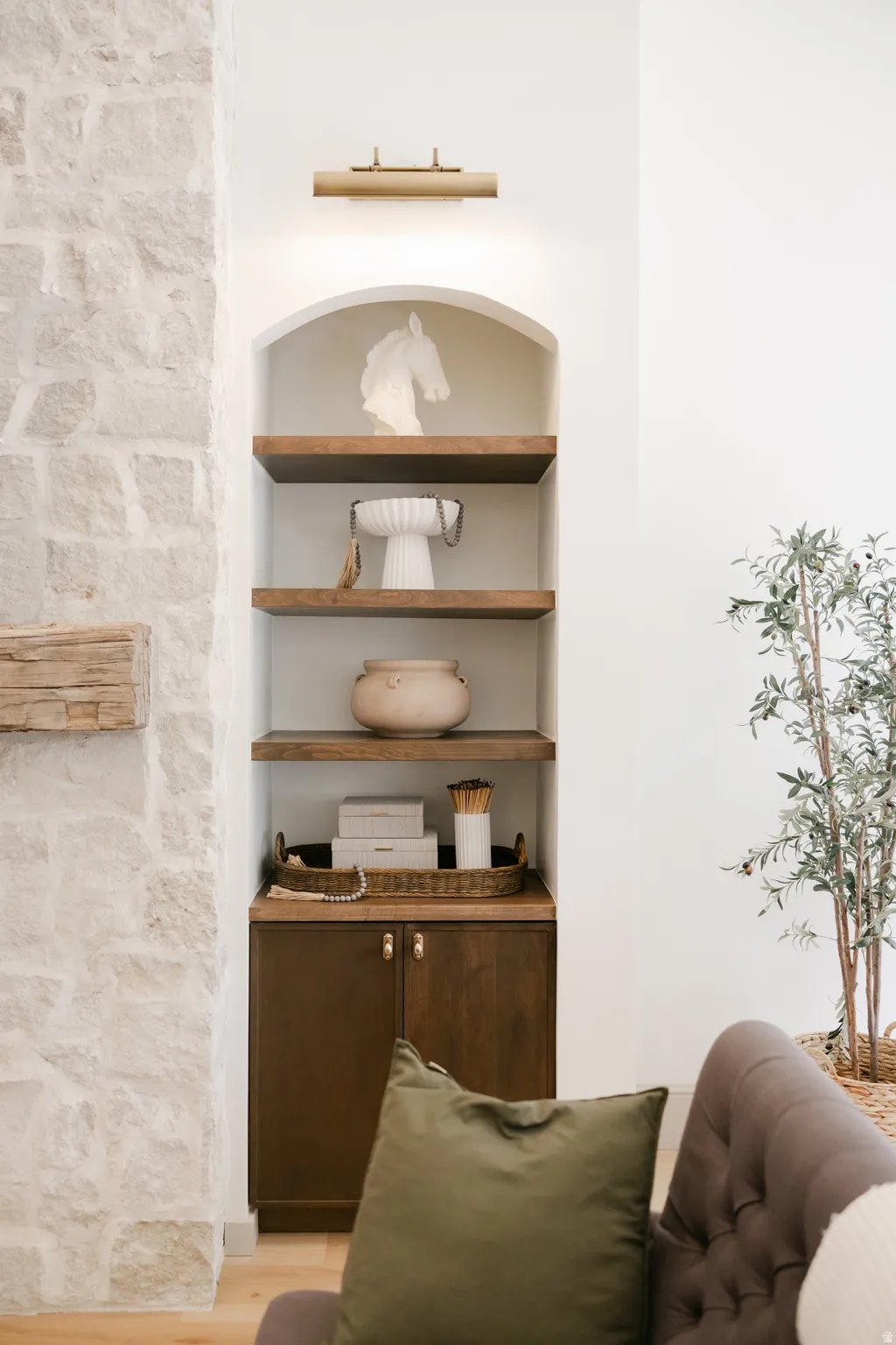 Built-in arched shelving with wood-finish shelves, integrated lighting, and lower cabinetry