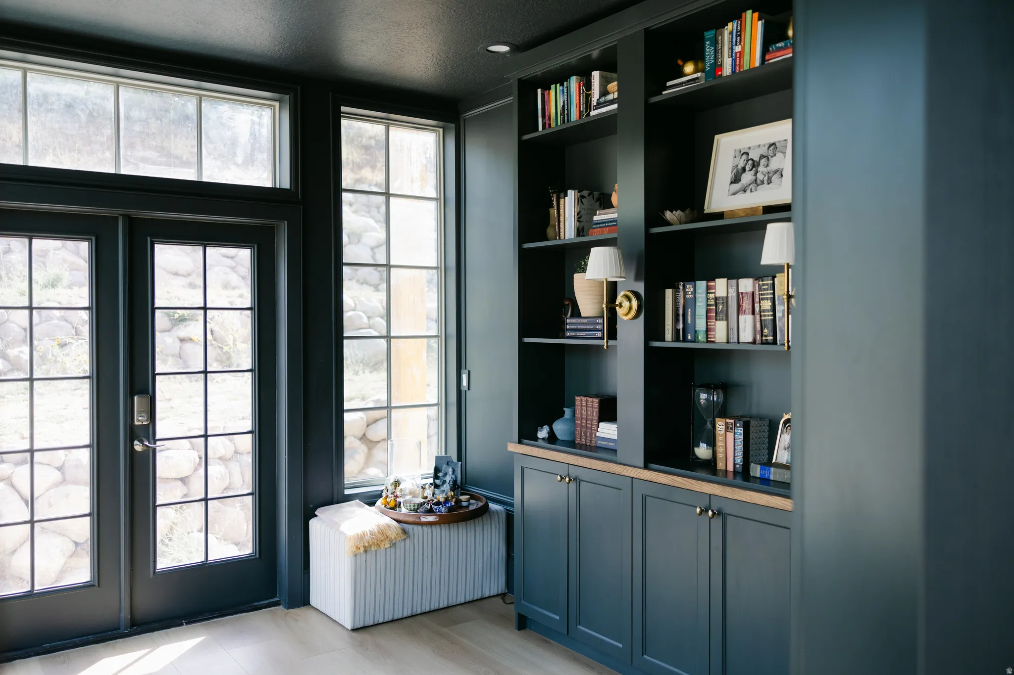 Built-in shelving with integrated cabinetry, wood-finish countertop, and wall-mounted sconces