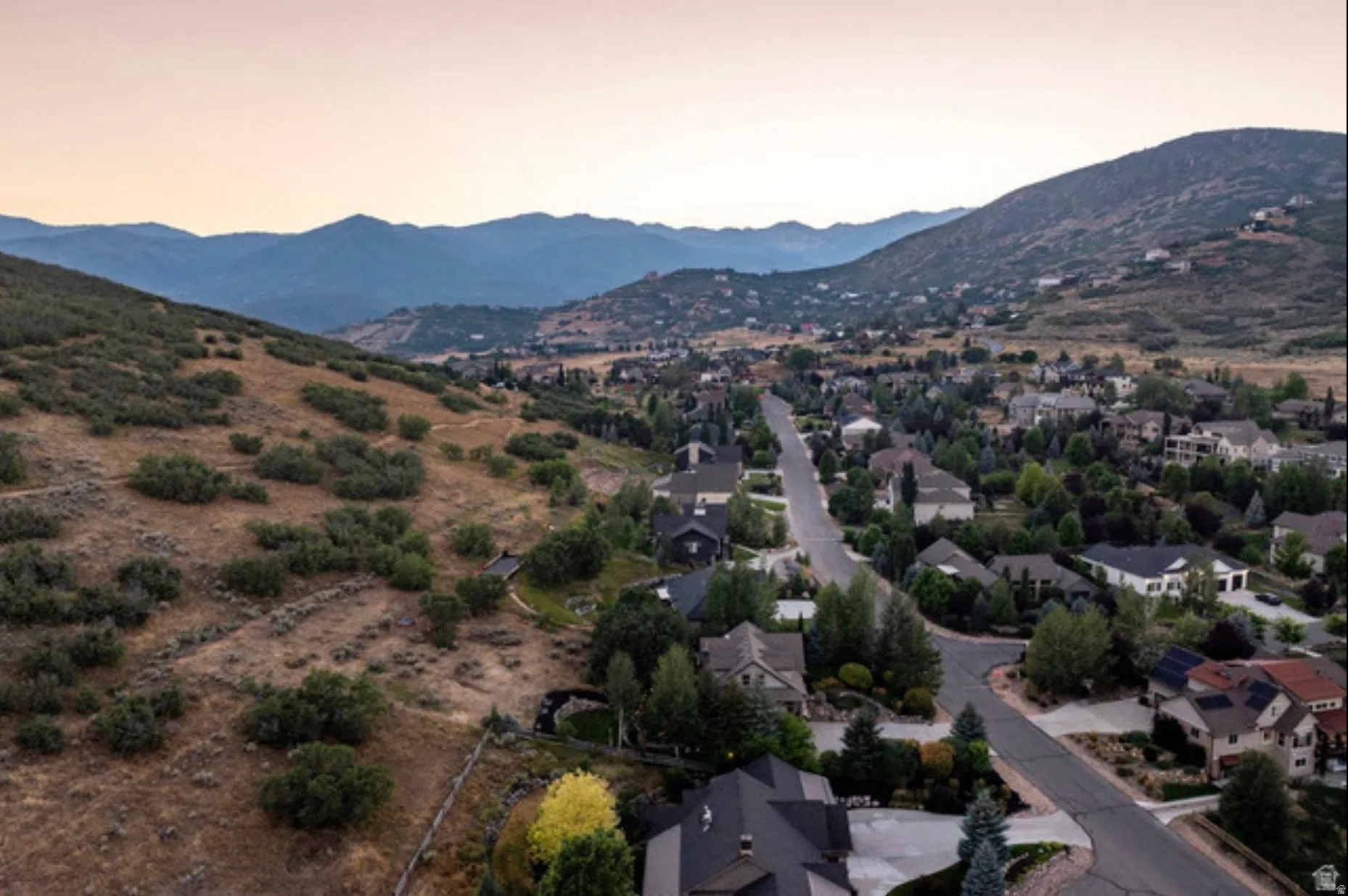 Expansive mountainous landscape with scattered residential properties and established roadways