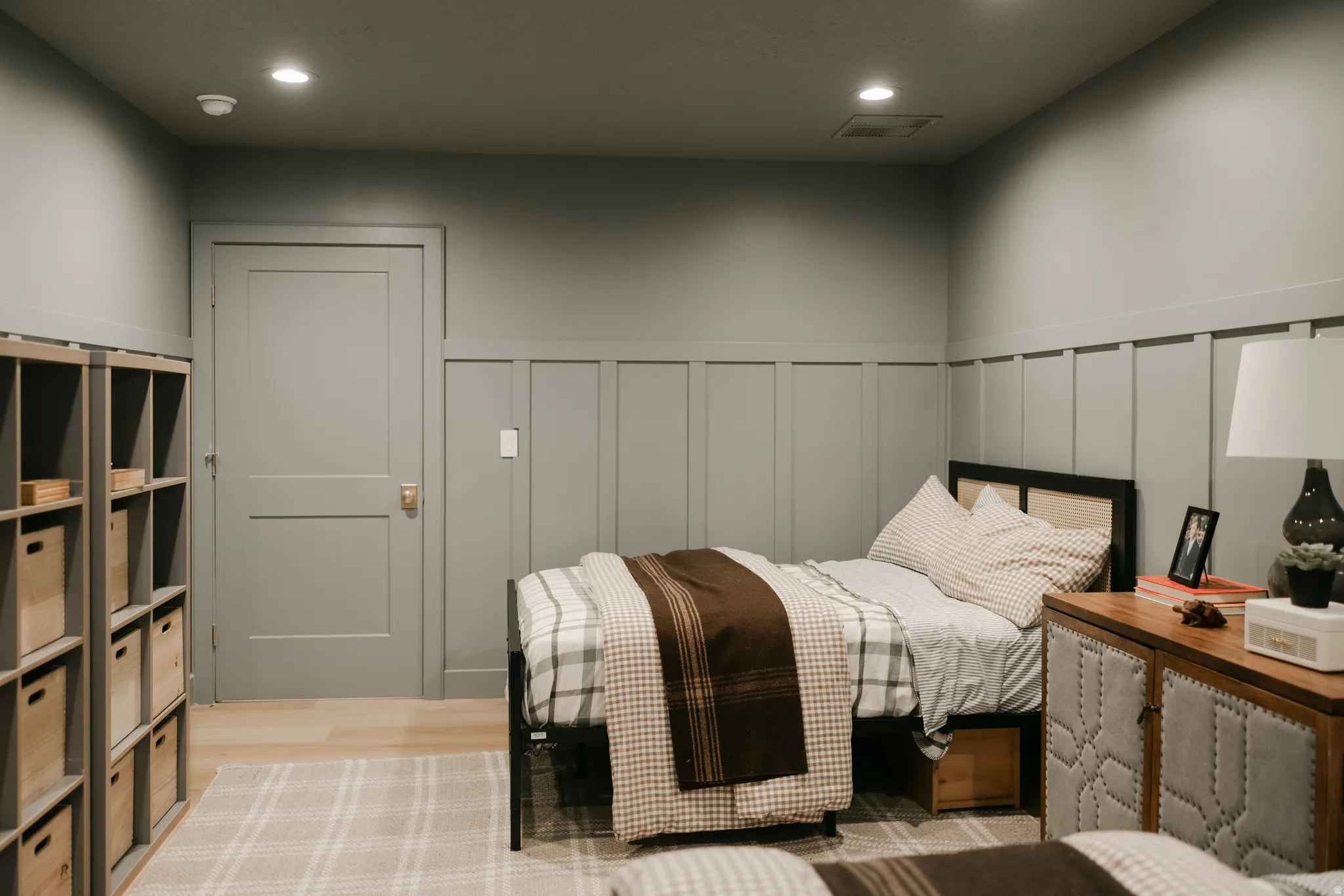Recessed lighting, wood-finish flooring, board and batten wainscoting, and a flat-panel door