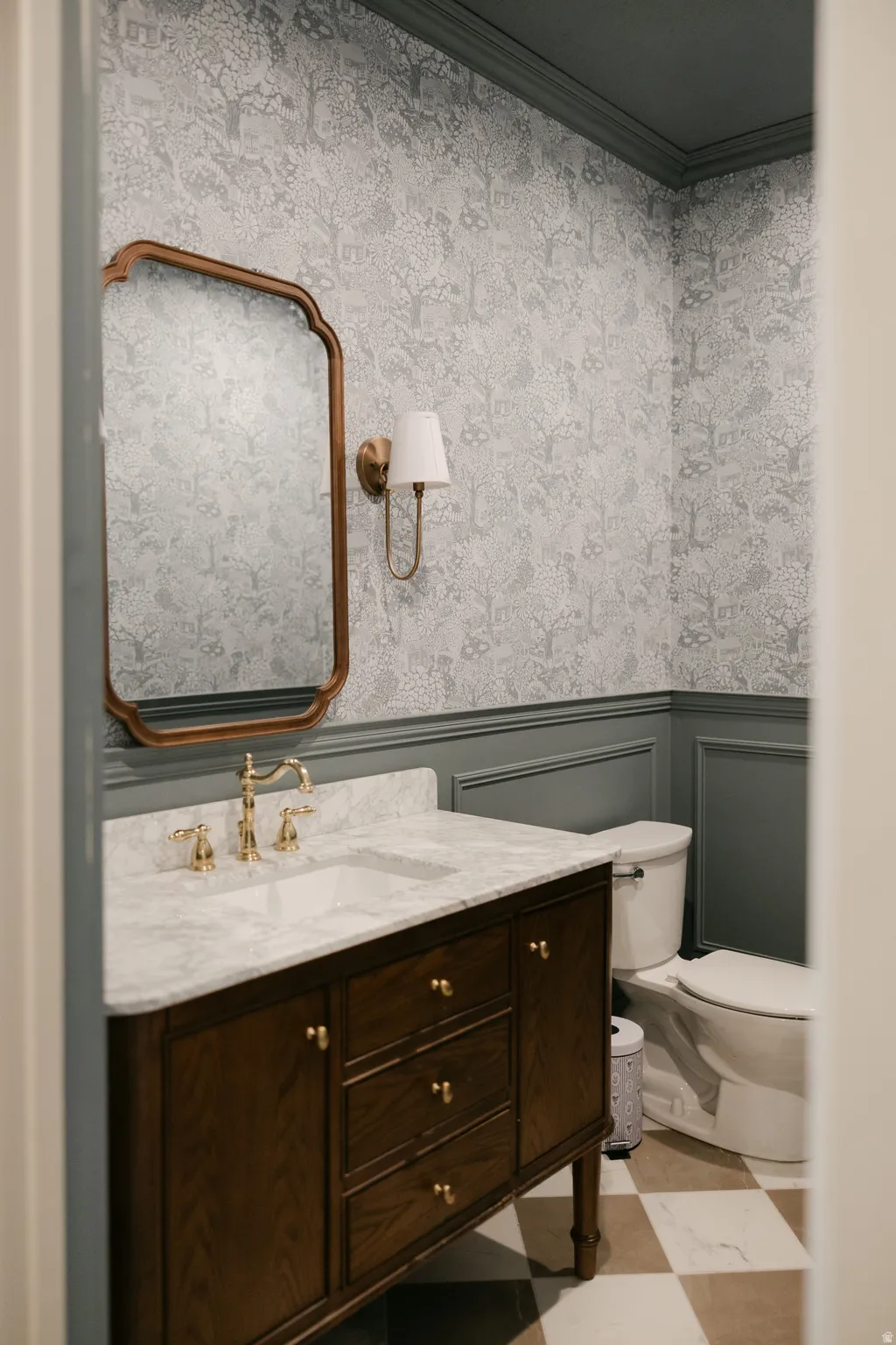 Wood-finish vanity with a marble-finish countertop and brass fixtures