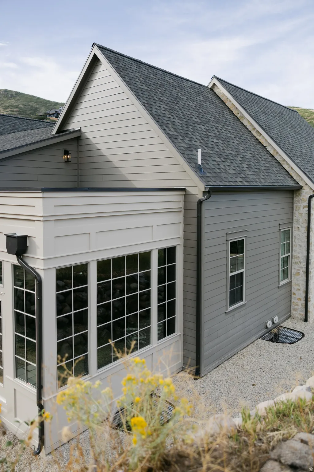 Gable roofline with dark shingles and light gray horizontal siding