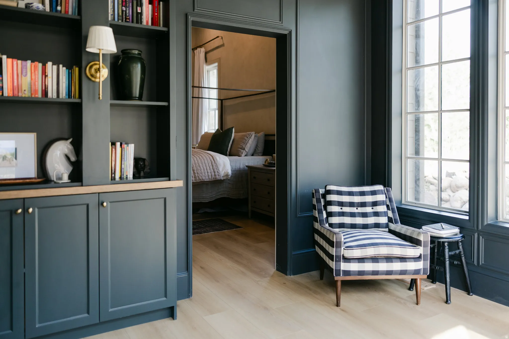 Built-in shelving with lower cabinetry, wood-finish flooring, and large multi-pane windows