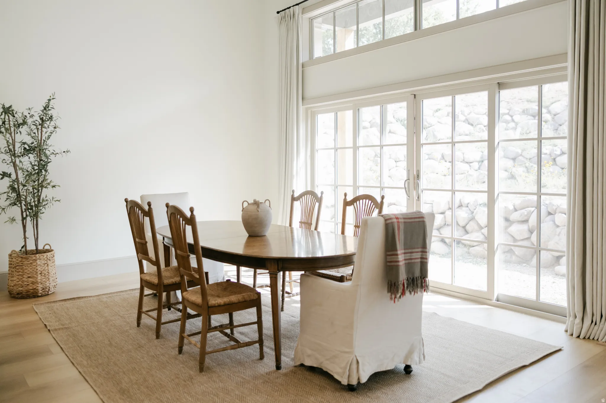 Hardwood-style flooring, expansive sliding glass doors, transom windows, and white walls
