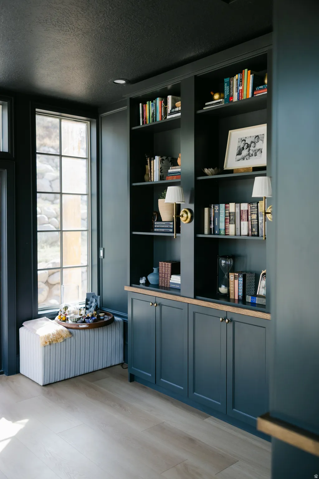 Built-in custom cabinetry with brass hardware, integrated shelving, and wood-finish flooring
