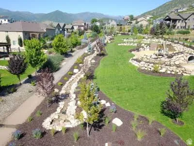 Manicured lawn with mature trees and a paved pathway