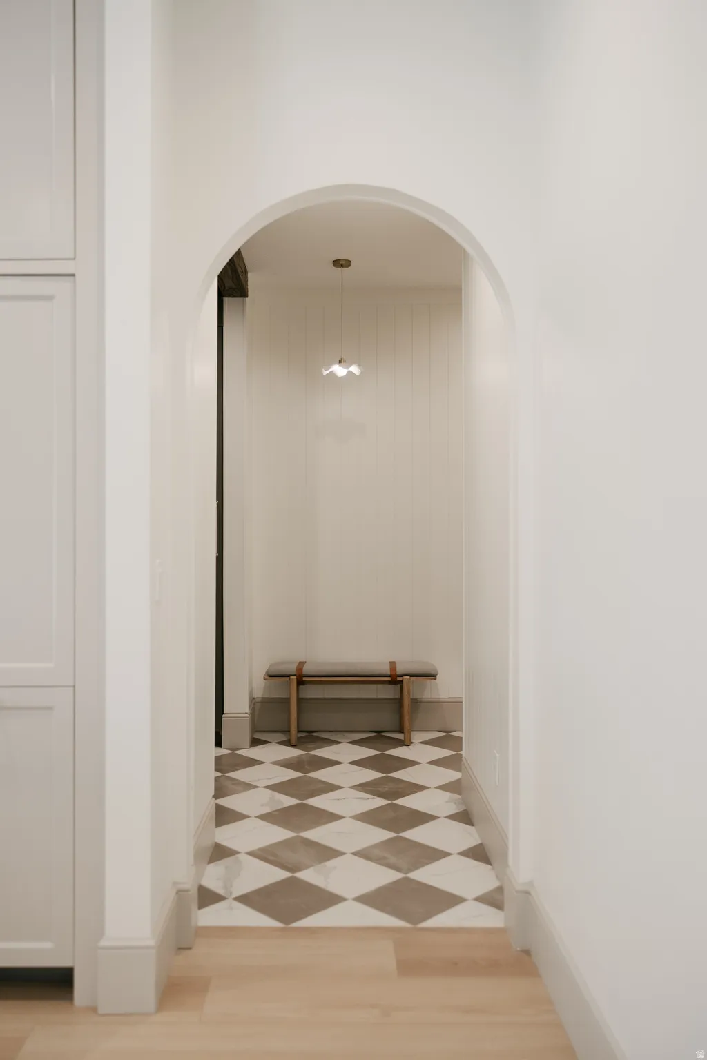 Arched entryway featuring diamond-patterned tile flooring and a ceiling-mounted light fixture