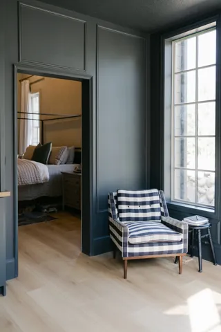 Architectural wall paneling, light wood-finish flooring, and a multi-pane window