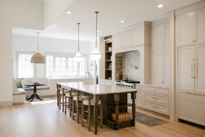Spacious kitchen featuring an expansive center island with seating, integrated appliances, and a built-in banquette