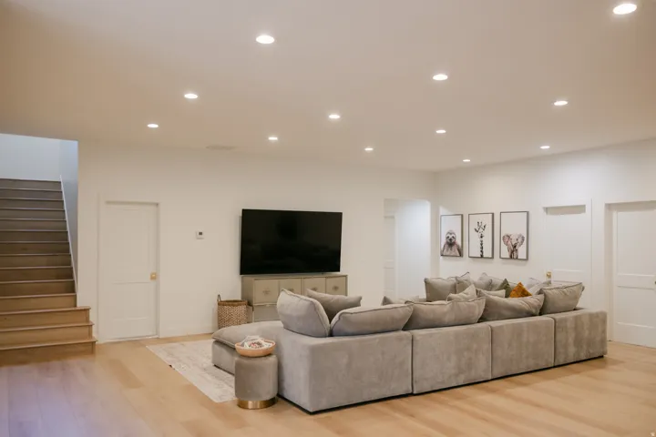Recessed ceiling lighting, light wood-finish flooring, and white two-panel doors