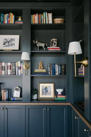Built-in cabinetry with paneled doors, brass hardware, and wood-finish countertops