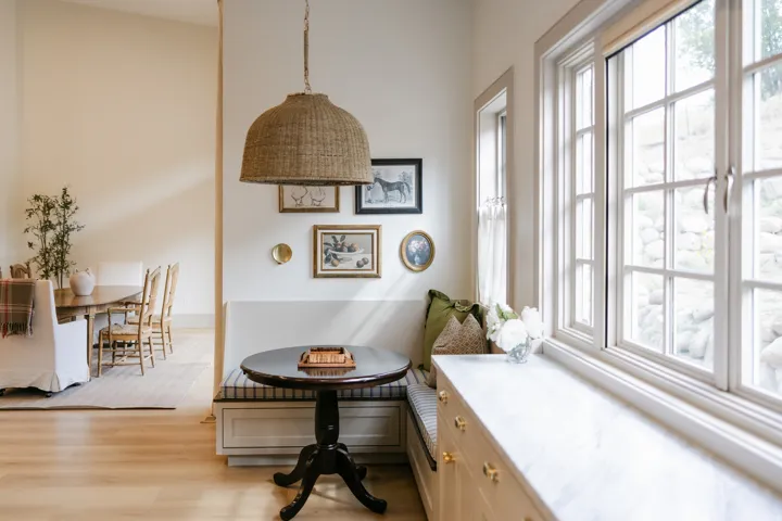 Built-in banquette seating, a large multi-pane window, and light wood-finish flooring