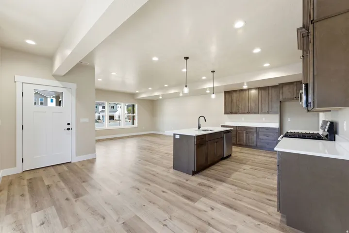Open concept living space featuring wood-finish flooring, recessed lighting, and a modern kitchen