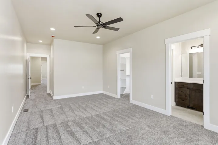 Spacious room featuring patterned carpet, a ceiling fan, recessed lighting, and white trim
