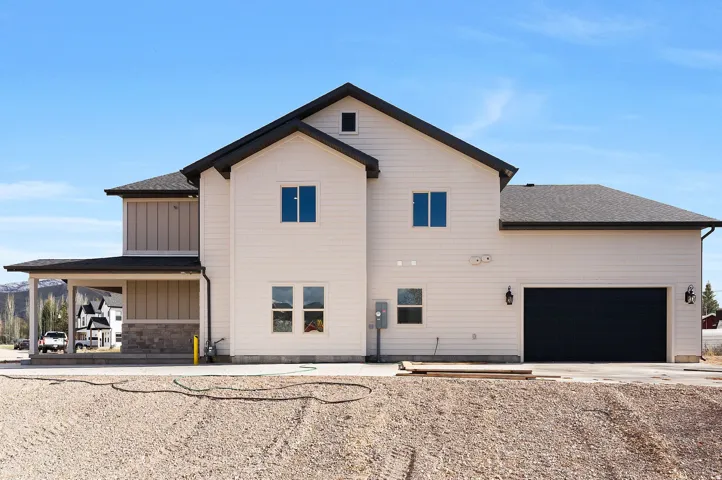 Two-story exterior with light-toned siding and dark roof