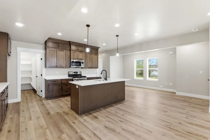 Kitchen featuring a central island, wood-finish flooring, recessed lighting, and ample cabinetry