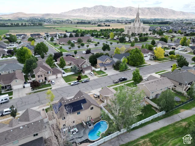 Residential property featuring a backyard swimming pool, solar panels, and mountainous surroundings