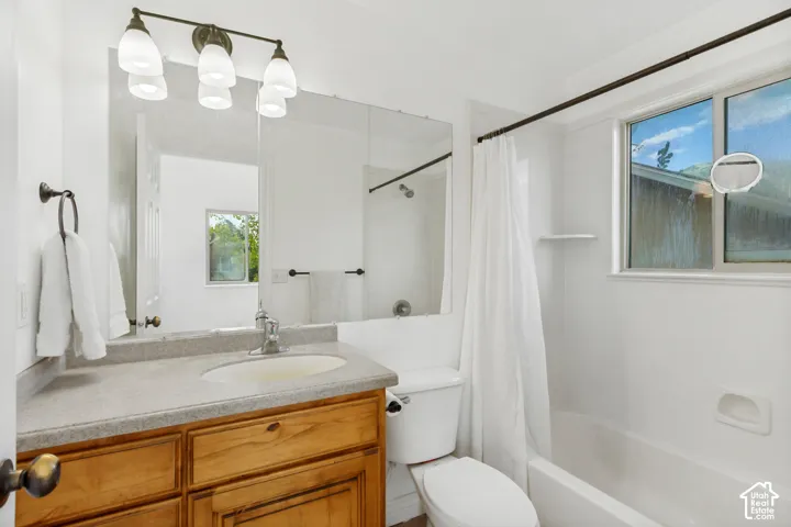 Wood-finish vanity with a light-toned countertop, integrated sink, and contemporary faucet