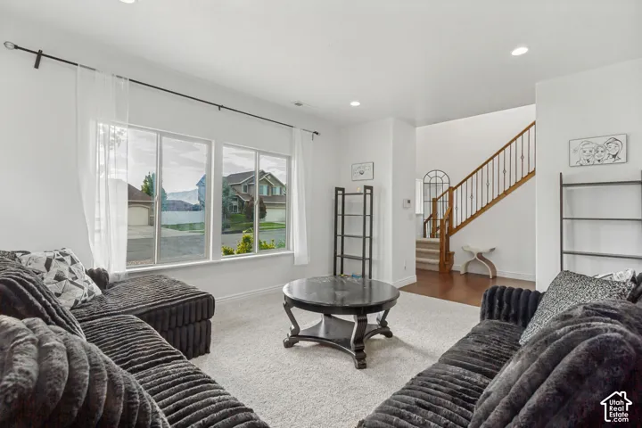 Spacious living area featuring large windows, recessed lighting, and carpet flooring