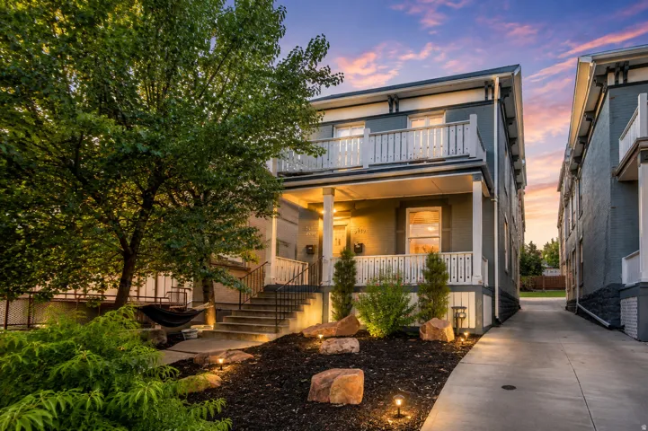 Two-story exterior with a covered porch and upper balcony featuring white railings