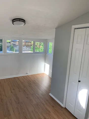Wood-finish flooring, multiple windows, bi-fold closet doors, and recessed ceiling lighting