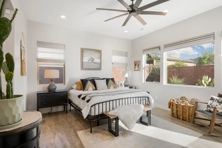 Wood-finish flooring, recessed lighting, ceiling fan, multiple windows with blinds, and white walls