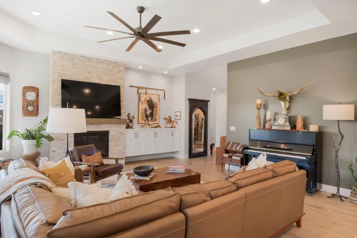 Living area featuring a stone-clad fireplace, recessed lighting, and a ceiling fan