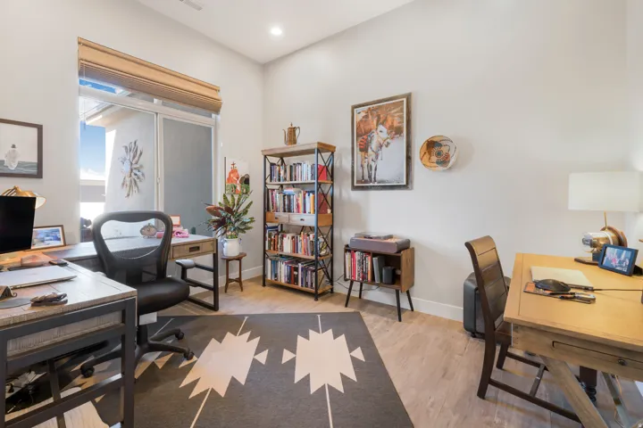 Wood-finish flooring, recessed lighting, and a large window with roller shades