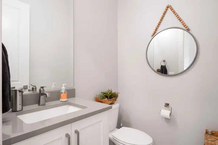 Vanity with white shaker-style cabinetry, gray countertop, and undermount sink