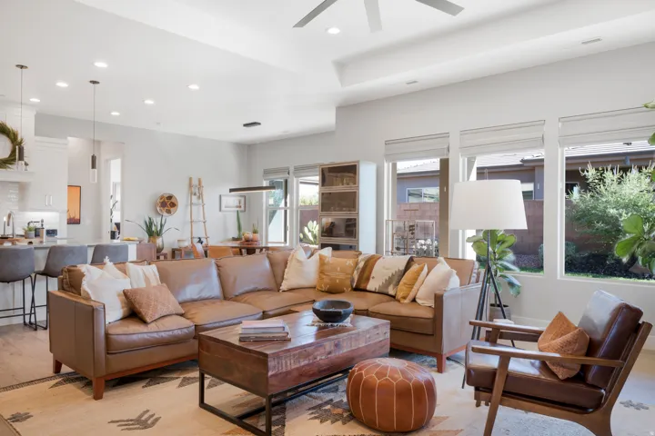 Open-concept living area featuring a tray ceiling with a ceiling fan, recessed lighting, and wood-finish flooring