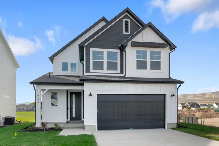 Modern farmhouse exterior featuring dark gray siding and white board-and-batten accents